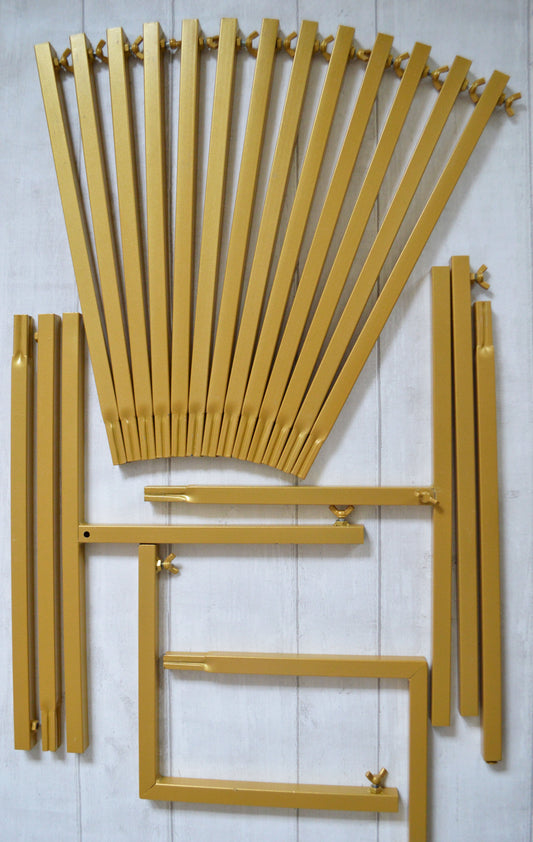 Flat lay of gold metal bars and wing nuts which will for a backdrop stand when constructed